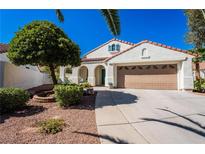 Inviting single-story home features a well-manicured front yard, a two-car garage and a terracotta roof at 1847 Vista Pointe Ave, Henderson, NV 89012