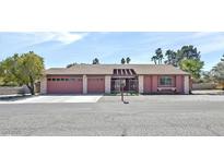 Charming single-story home featuring a well-maintained front yard, a two-car garage and a welcoming entryway at 2221 Mohawk St, Las Vegas, NV 89146