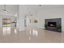 Bright living room featuring tile flooring, a stone fireplace, and a ceiling fan at 488 Chelsea Dr, Henderson, NV 89014