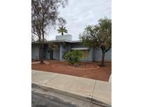 Charming single-story home featuring desert landscaping, concrete walkway, and trees at 569 Canosa Ave, Las Vegas, NV 89104