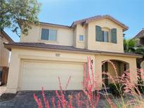 Inviting two-story home with a two-car garage, desert landscaping, and charming architectural details at 6245 Blushing Willow St, North Las Vegas, NV 89081