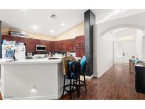 Cozy kitchen with wood cabinets, white countertops and bar stool seating, perfect for casual dining and entertaining at 6711 Quarterhorse Ln, Las Vegas, NV 89148