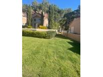 Charming exterior view featuring lush green lawn and mature trees at 8170 Round Hills Cir, Las Vegas, NV 89113