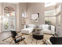 Bright living room featuring high ceilings, large windows, and a comfortable white sectional sofa at 85 Green Isle Cir, Henderson, NV 89074