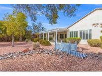Charming backyard featuring a covered patio, serene landscaping, and a quaint decorative bridge feature at 2463 Palmer Park Ct, Henderson, NV 89052