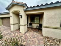 Charming single story home with covered entryway and two chairs on a brick paver landing at 2790 Chetco River St, Laughlin, NV 89029