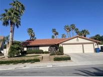 Inviting single-story home featuring a terracotta tile roof, desert landscaping, and a three-car garage at 3417 Iberia St, Las Vegas, NV 89146