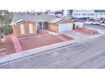 Charming single-story home with a gravel yard, solar panels, and a paved driveway leading to a two-car garage at 4735 Monterrey Ave, Las Vegas, NV 89121