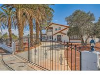 Charming home featuring a two-story design, mature landscaping, and a gated driveway for added privacy at 7079 Laredo St, Las Vegas, NV 89117