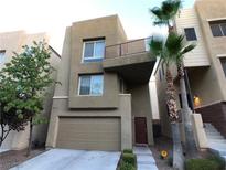 Modern two-story home featuring a front-facing garage, a balcony and desert landscaping at 9359 Brigham Ave, Las Vegas, NV 89178