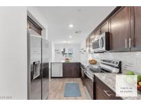 Modern kitchen featuring stainless steel appliances, granite countertops, and dark wood cabinetry at 12367 Indigo Montage Rd # 3, Las Vegas, NV 89183