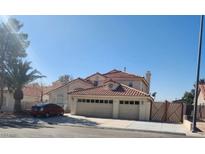 Two-story home featuring a red tile roof, a three-car garage, and lush landscaping in a well-maintained front yard at 1255 Del Lilly Ln, Las Vegas, NV 89123