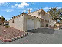 Two-story stucco house featuring an attached two-car garage and exterior staircase to a balcony with terracotta roof tiles at 1900 N Torrey Pines Dr # 216, Las Vegas, NV 89108