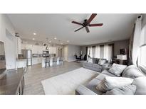Open-concept living room features modern furnishings, wood-look flooring, and seamless flow into the kitchen at 2539 Ballatore St, Henderson, NV 89044