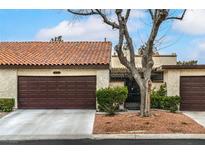Charming single-story home featuring a brown garage door, stucco walls, and a red tile roof at 3053 Conquista Ct, Las Vegas, NV 89121