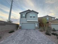 Charming two-story home with a gray exterior, two-car garage and patterned brick driveway at 5691 Tinar St, Las Vegas, NV 89113