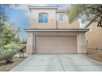 Inviting two-story home featuring a well-maintained front yard, a neutral color palette, and an attached two-car garage at 653 Del Giorno St, Las Vegas, NV 89138
