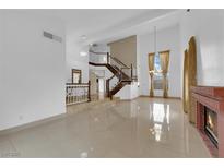 Bright, open living room with staircase, fireplace, and tile floors at 738 Panhandle Dr, Henderson, NV 89014