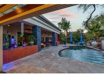 Inviting backyard featuring a covered patio, a luxurious pool, and meticulously landscaped greenery under a beautiful sunset sky at 7436 Oak Grove Ave, Las Vegas, NV 89117