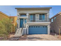 Two-story home featuring a blue garage door, a balcony, and a charming front yard at 7745 Tyrell Peaks St, Las Vegas, NV 89139
