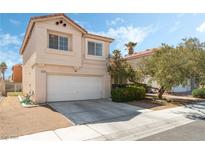 Two-story home featuring a two-car garage, neutral stucco, and well-maintained landscaping under a bright blue sky at 8729 Country View Ave, Las Vegas, NV 89129