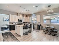 Stylish kitchen featuring an island with seating, modern stainless appliances, and elegant pendant lighting at 9611 Trattoria St, Las Vegas, NV 89178