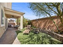 Relaxing backyard featuring a covered patio, lounge chairs, and well-manicured landscaping at 168 Springhouse St, Las Vegas, NV 89148