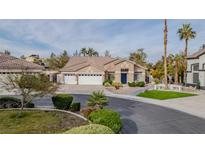 Charming single-story home with a three-car garage, desert landscaping, and a welcoming blue door at 1720 Sand Storm Ct, Henderson, NV 89074