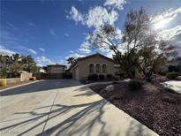 Charming single-story home featuring a spacious driveway, desert landscaping, and detached garage at 289 Ivywood Ct, Las Vegas, NV 89183