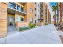 Beautiful condo exterior featuring multiple levels, balconies, and meticulous landscaping with palm trees at 353 E Bonneville Ave # 125, Las Vegas, NV 89101