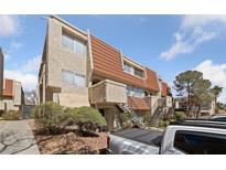 Exterior view of a multi-level townhome with textured walls, red roof tiles and a well maintained landscape at 3597 Arville St # 201B, Las Vegas, NV 89103