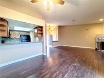 Open living room and kitchen with hardwood floors, tile backsplash, and stainless steel appliances at 6250 W Flamingo Rd # 11, Las Vegas, NV 89103