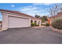 Charming single-story home featuring a red tile roof, attached two-car garage and landscaped front yard at 735 Sea Pines Ln, Las Vegas, NV 89107