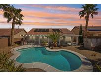 Backyard view of the private pool, tropical landscaping and covered patio of this charming single-Gathering home at 1019 Amber Gate St, Henderson, NV 89002