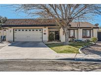 Charming single-story home featuring a two-car garage, manicured lawn, and a welcoming front porch at 2412 El Cid Ct, Henderson, NV 89014