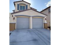 Attached two-car garage with gray doors and concrete driveway on a stucco two-story home at 2431 Lilac Cove St, Las Vegas, NV 89135