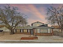 Charming single-story home with brick accents, mature trees and a driveway at 4155 Comb Cir, Las Vegas, NV 89104