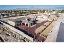 Stunning aerial view of the custom home, desert landscaping, and lengthy driveway leading up to the three-car garage at 8509 Iron Mountain Rd, Las Vegas, NV 89143