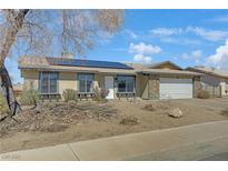 Charming single-story home featuring a low-maintenance front yard and solar panels on the roof at 413 Pumpkin Way, Henderson, NV 89015
