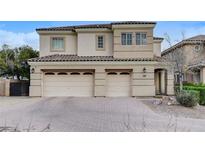 Charming two-story home featuring a three-car garage, tile roof, and manicured front yard at 5588 Holcomb Bridge Ct, Las Vegas, NV 89149