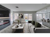 Bright living room featuring a fireplace, backyard view, and modern decor at 71 Sea Holly Way, Henderson, NV 89074