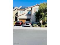 Two-story home featuring a two-car garage, front yard landscaping, and solar panels on the roof at 8036 Maple Park St, Las Vegas, NV 89131
