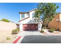 Charming two-story home featuring a red garage door, landscaped yard, and a well-manicured lawn under a clear blue sky at 9092 Sosa Creek Ave, Las Vegas, NV 89149