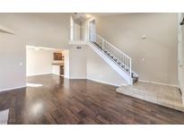 Open-concept living area with high ceilings, hardwood floors, and staircase to the second floor at 10199 Rising Tree St, Las Vegas, NV 89183