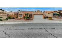 Charming single-story home with a well-manicured front yard and a two-car garage on a sunny day at 1925 Hot Oak Ridge St, Las Vegas, NV 89134
