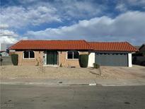 Charming single-story home with red tile roof, brick facade, security door, and two car garage at 3672 Madrid St, Las Vegas, NV 89121