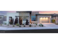 Modern home featuring neutral colors, stone accents, manicured landscaping, and a spacious driveway and garage at 381 Cliff Terrace Ave, Las Vegas, NV 89138