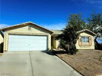 Inviting single-story home featuring a two-car garage, desert landscaping, and a classic design at 5406 Indigo Hills St, North Las Vegas, NV 89031