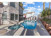 A refreshing pool and spa combination with a lounge area, perfect for outdoor relaxation and entertainment at 8433 Honeywood Cir, Las Vegas, NV 89128
