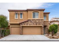 Charming home with a tan stucco exterior, stone accents, three-car garage, and well-maintained landscaping at 9869 White Lilac St, Las Vegas, NV 89178